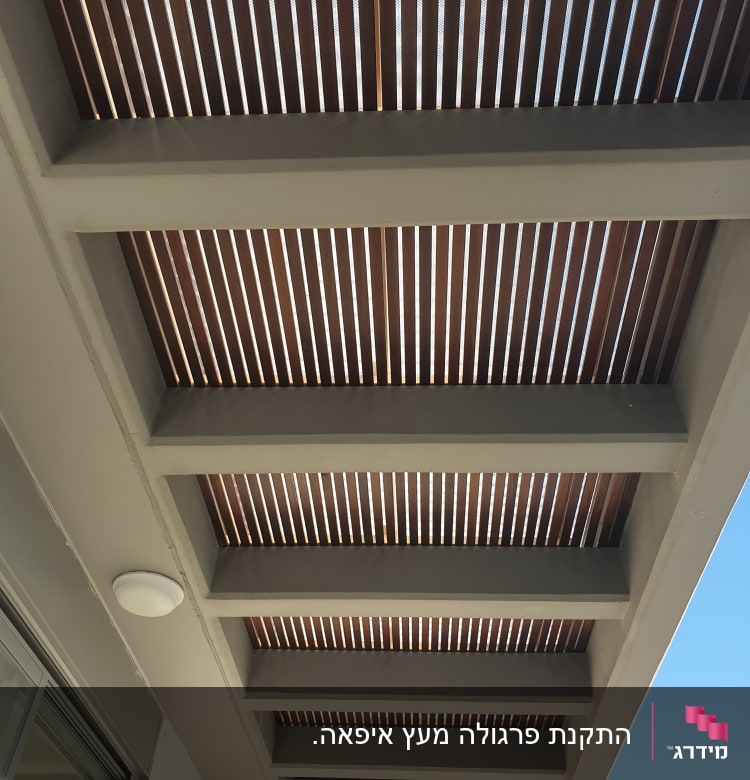 פרגולה מעץ עם קורות עץ חומות